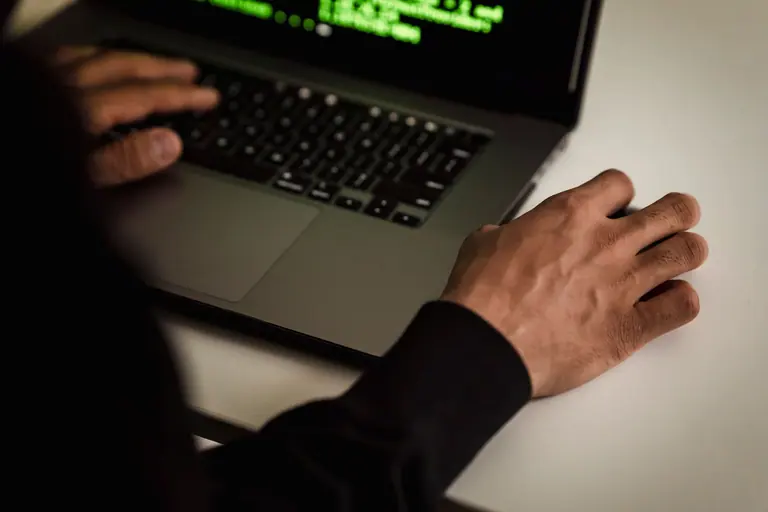 Hands working with a laptop and mouse during a technical review